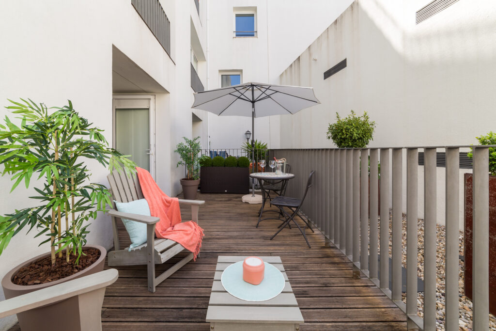 Grand balcon aménagé avec des meubles et des plantes