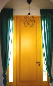 Porte jaune avec des rideaux verts autour
