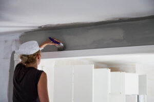 Femme qui peint un plafond en gris